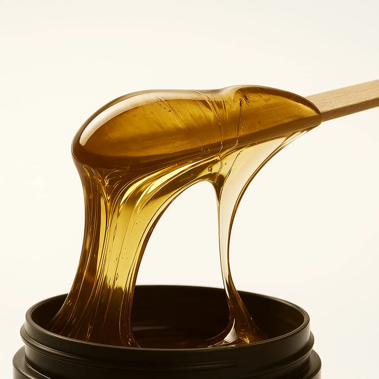 Nahaufnahme von Honigwachs auf einem Holzspatel – professionelle Waxing-Behandlung in München Haidhausen Nahaufnahme von Honigwachs auf einem Holzspatel – professionelle Waxing-Behandlung in München Haidhausen