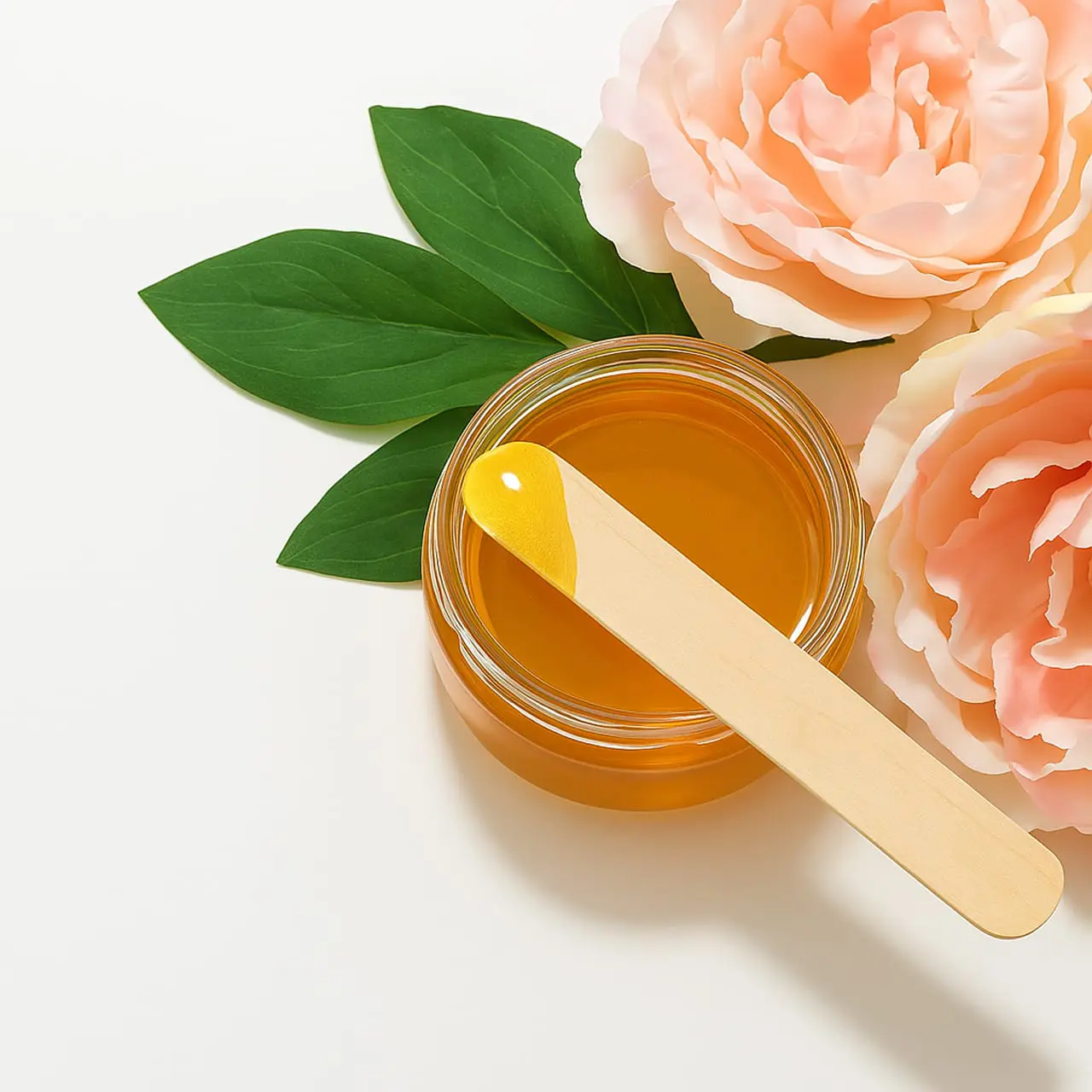 waxing-bild-mit-blumen-muenchen - Waxing München Haidhausen Waxing Wachs im Glas mit Holzspatel und floraler Deko – ästhetische Szene für Waxing in München Haidhausen