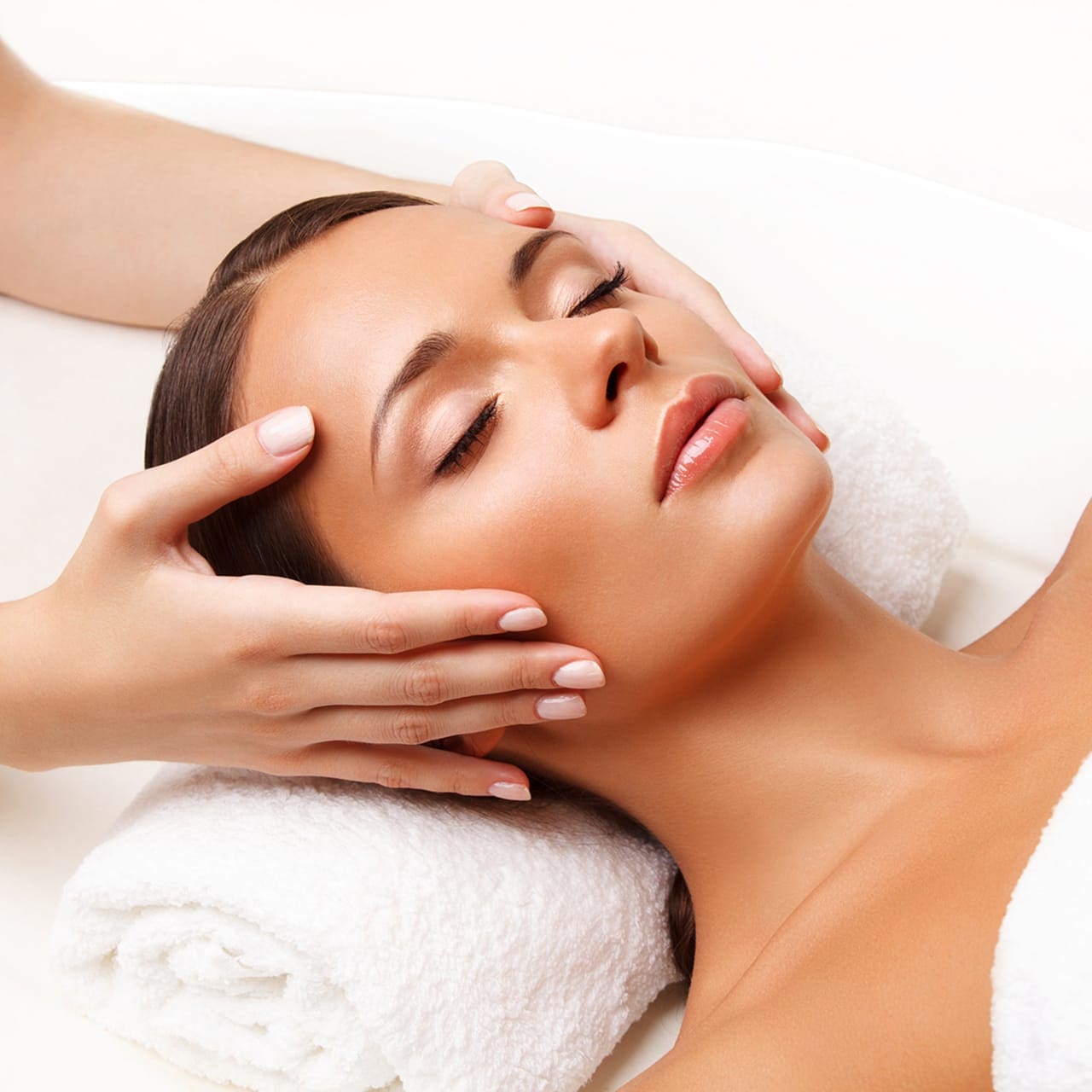 Gesichtslymphdrainage Haidhausen - Lymphdrainage im Gesicht – eine Frau liegt entspannt, während Kosmetikerin Erika Falise-Suryadi sanften Druck im oberen Gesicht ausübt