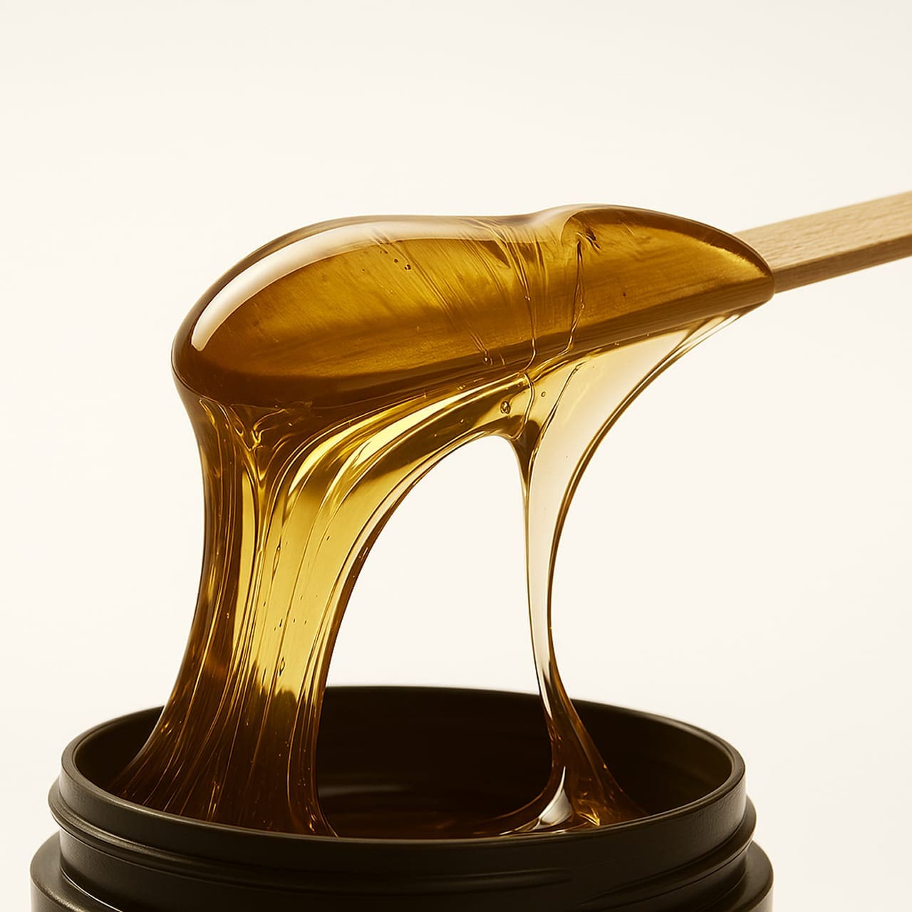 Nahaufnahme von Honigwachs auf einem Holzspatel – professionelle Waxing-Behandlung in München Haidhausen